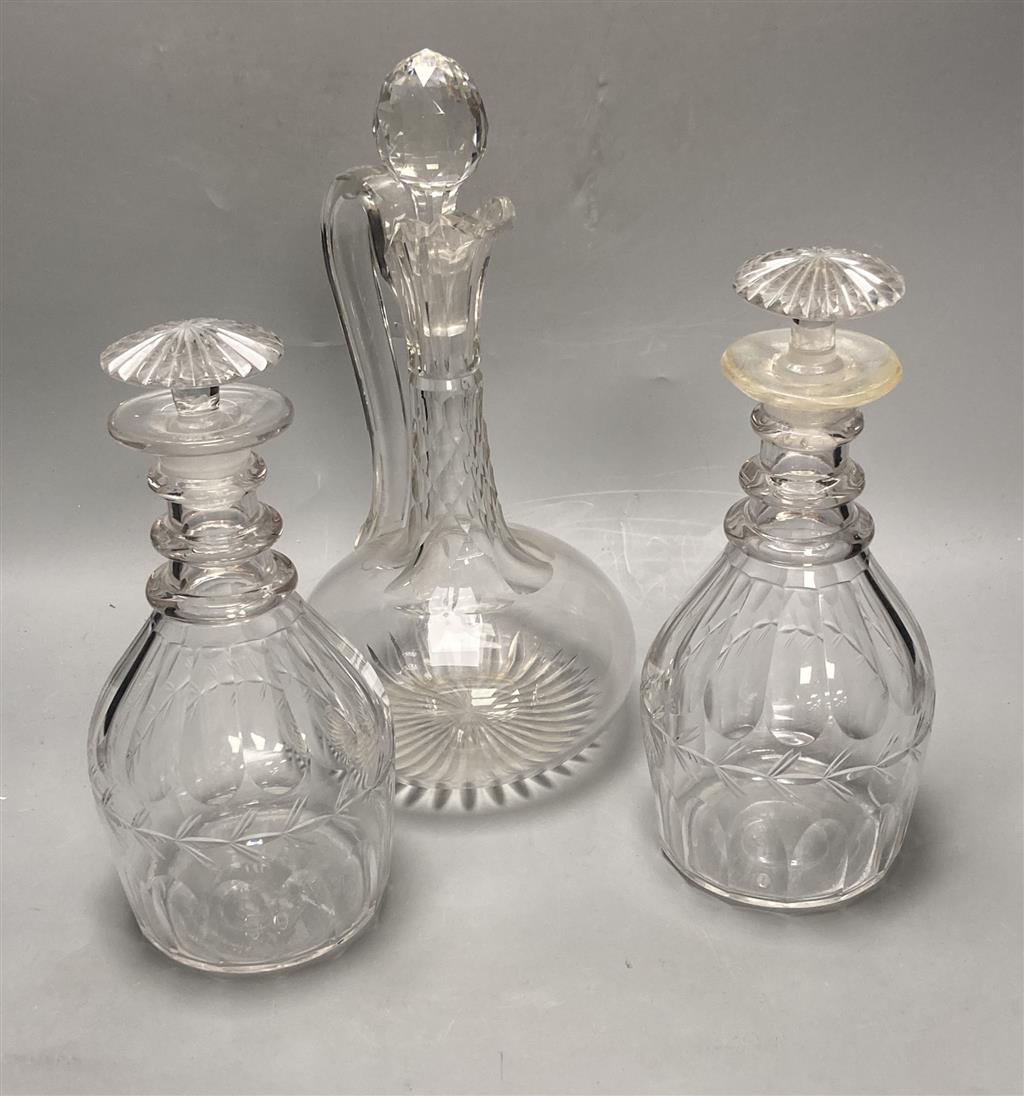 A pair of early 19th century cut glass decanters, height 24cm and an Edwardian claret jug, height 30cm (one decanter a.f.)